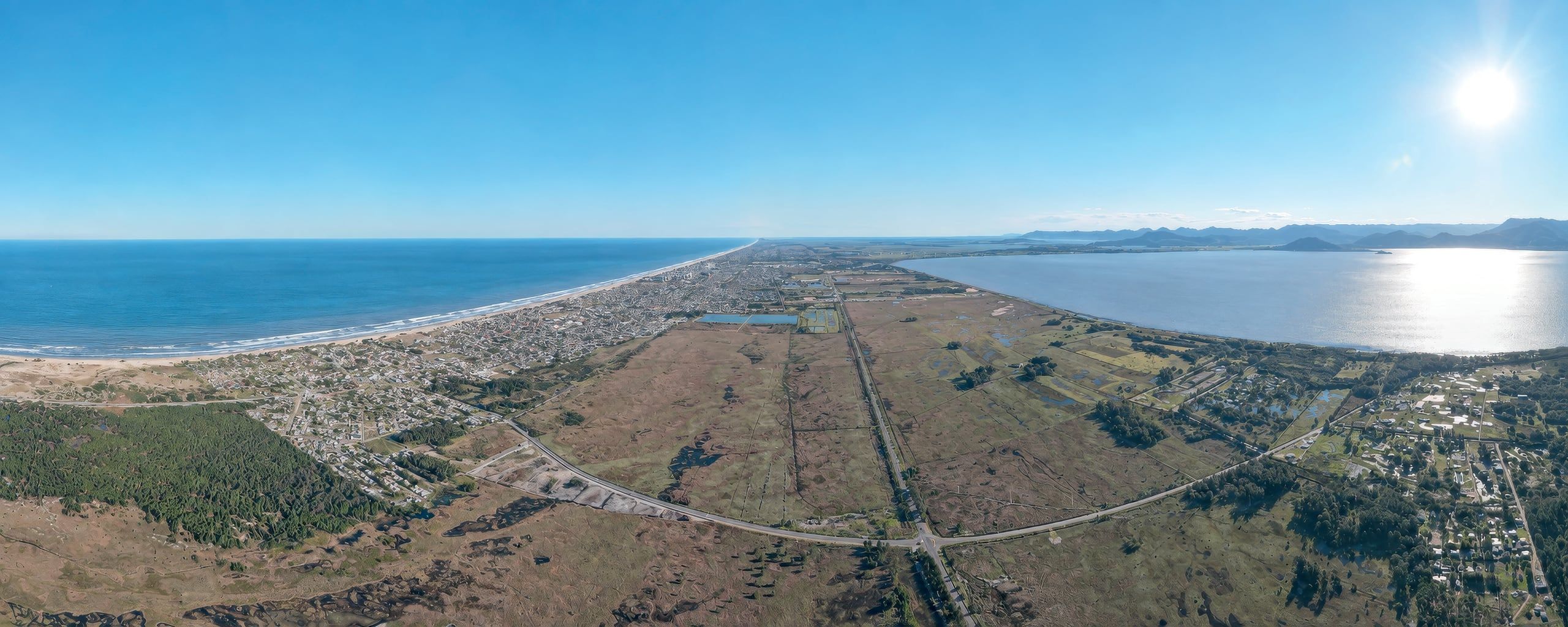 Vista aérea de Capão da Canoa: o mar à esquerda, a Lagoa dos Quadros à direita e a área do Barra Norte ao centro